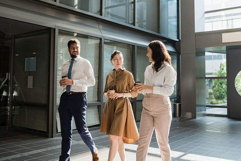 Group Of Engaged Colleagues Walking Through Lobby 