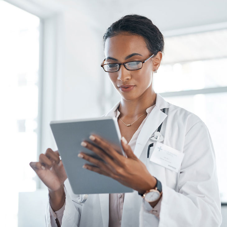 Doctor Reviewing Info On Tablet 