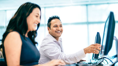 Happy Colleagues Collaborating At Desktop Screens 