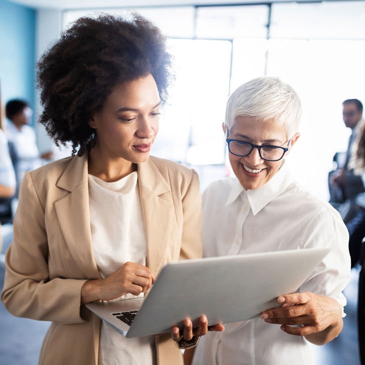 Multigenerational Colleagues Looking At Laptop 