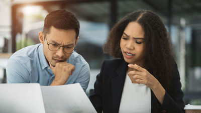 Two Colleagues Reviewing Documents And Laptop 
