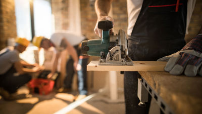 Close Up Of Carpenter Cutting Wood On Jobsite 