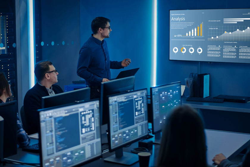 Colleagues Viewing Data In Dark Room