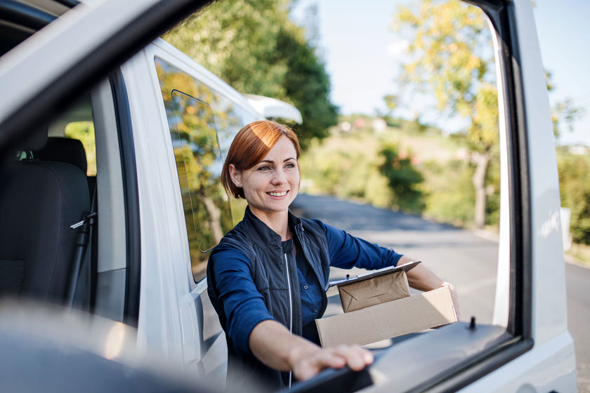 Person Getting Out Of Delivery Truck With Packages