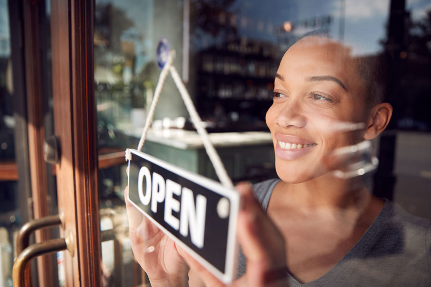 Person Smiling Turning Open Sign On Door 