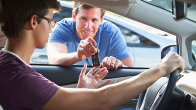 Adult Handing Car Key To Teenager 