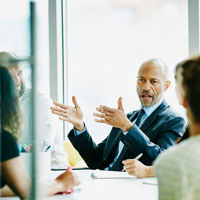 Colleagues Discussing Work Around Conference Table 