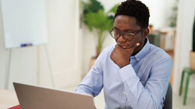 Young Worker Looking At Laptop Screen 