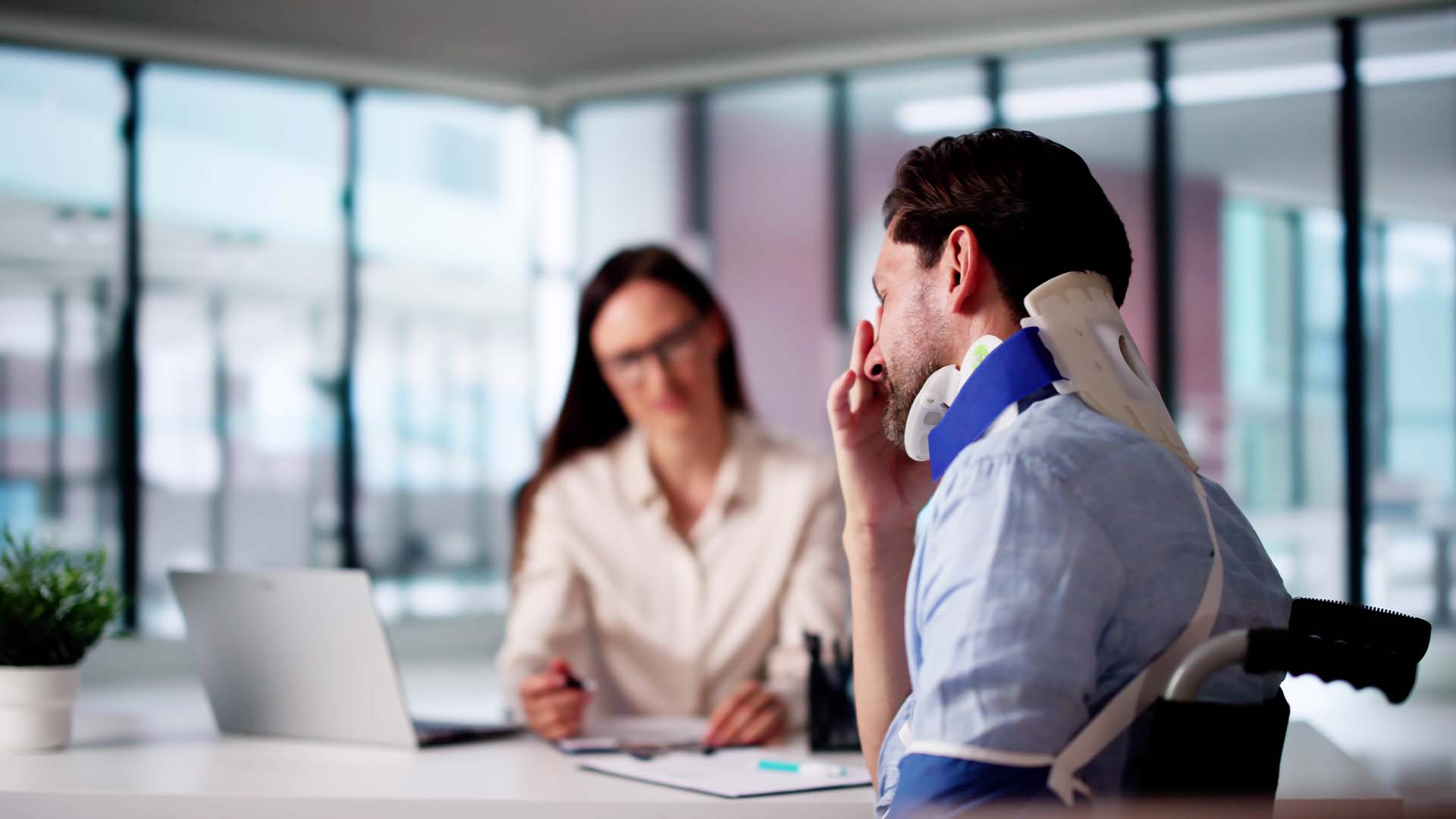 man-stressed-wearing-neck-brace-at-desk