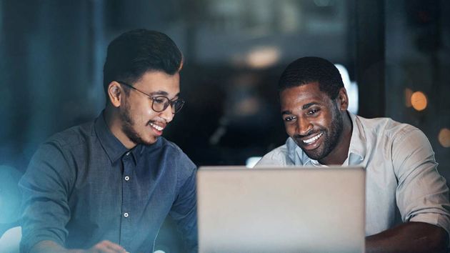 Two Male Coworkers Smiling At Laptop 