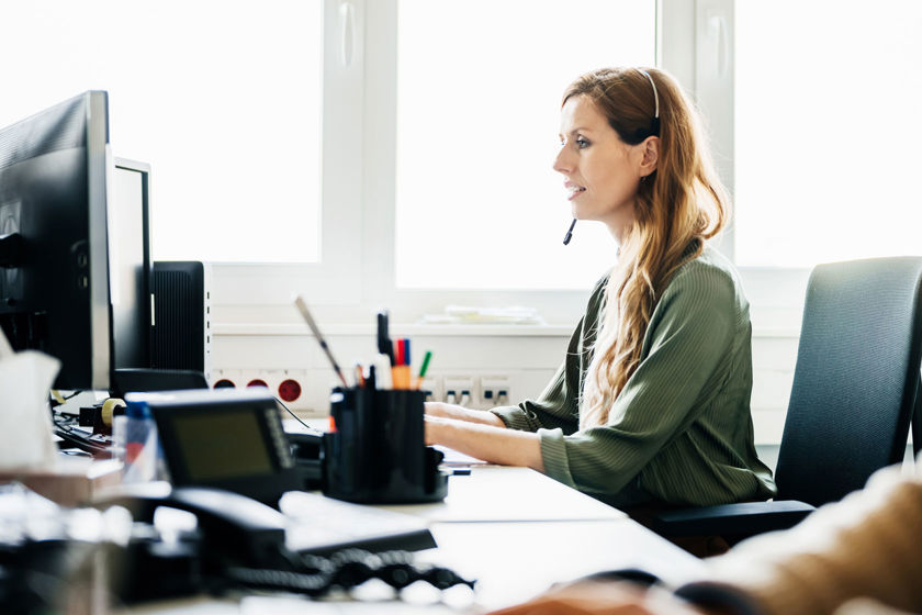 Office Worker At Computer Wearing Headset 
