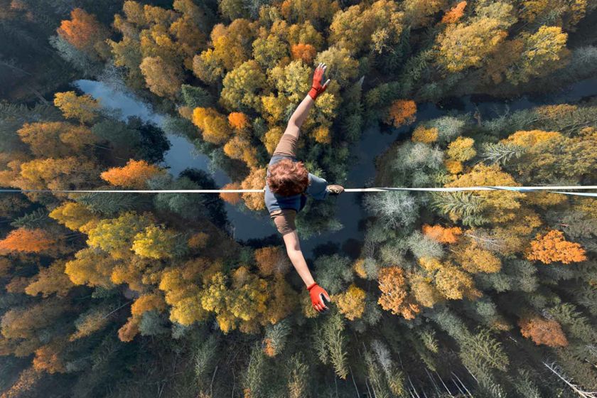 Tightrope Walker Balancing Above Treeline 