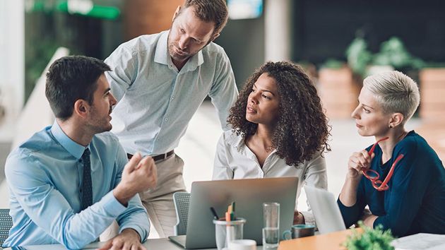 Coworkers Collaborating At Desk 