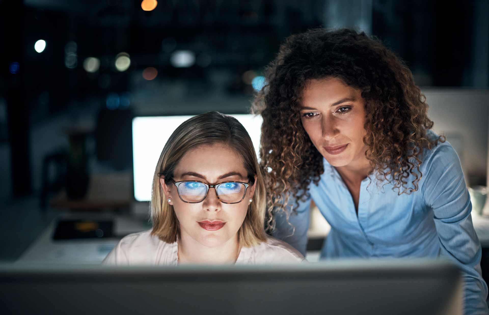 Two Colleagues Looking Intently At Data On Screen 