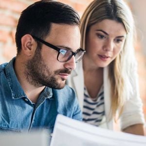 Coworkers Reviewing Data On Screen In Office 